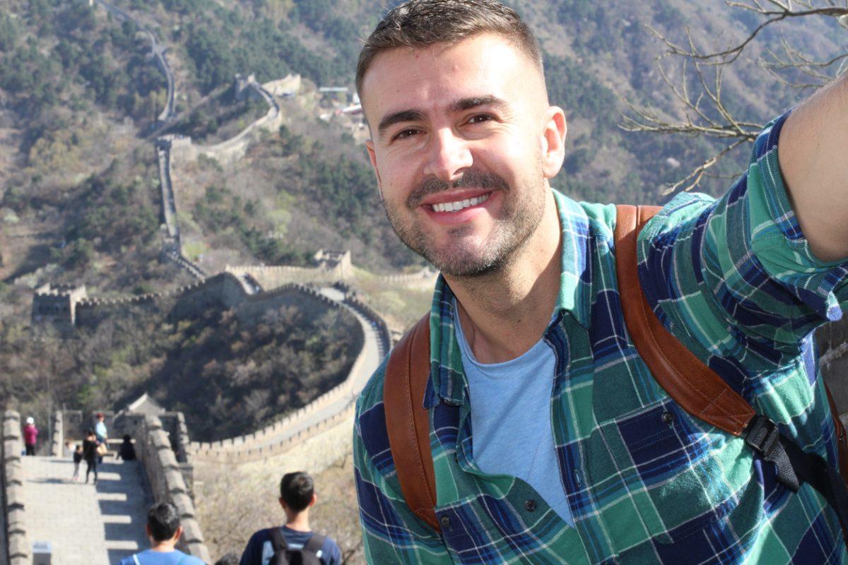 Excited tourist visiting the great wall of China.