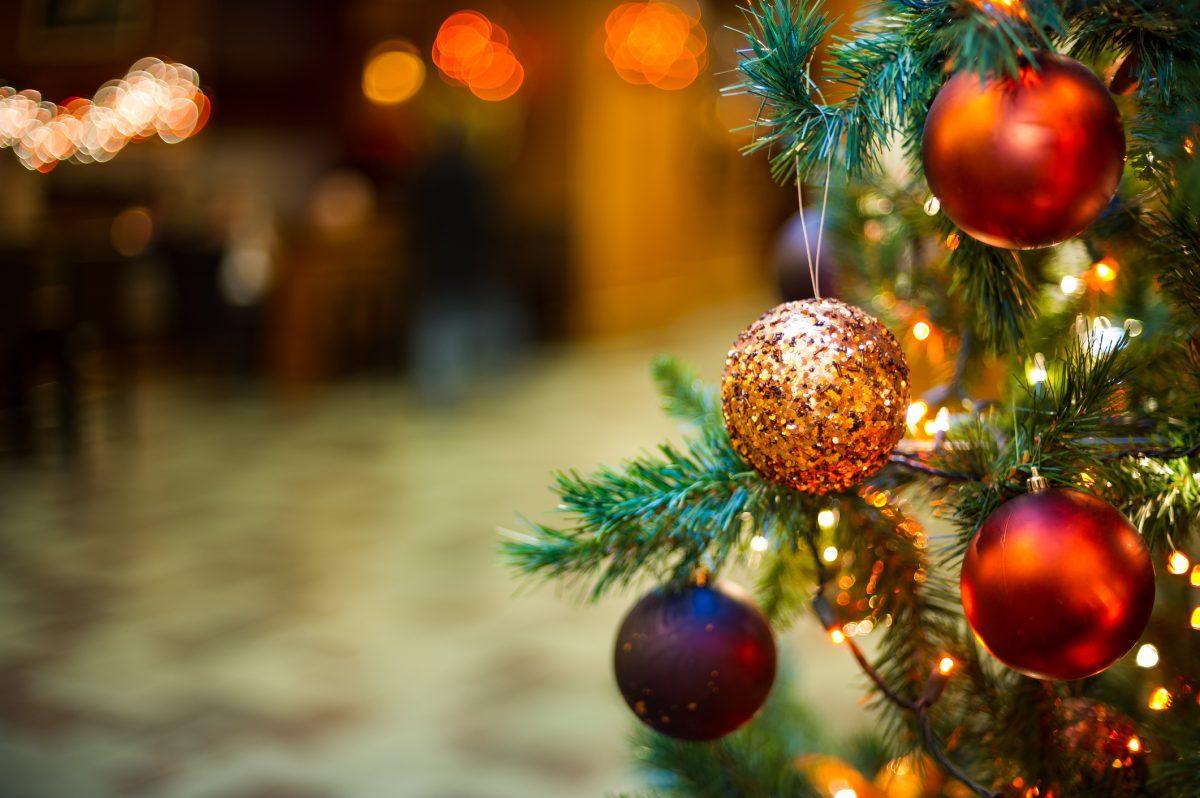 Close-up of baubles hanging on fir needles. Christmas tree is decorated with ornaments.
