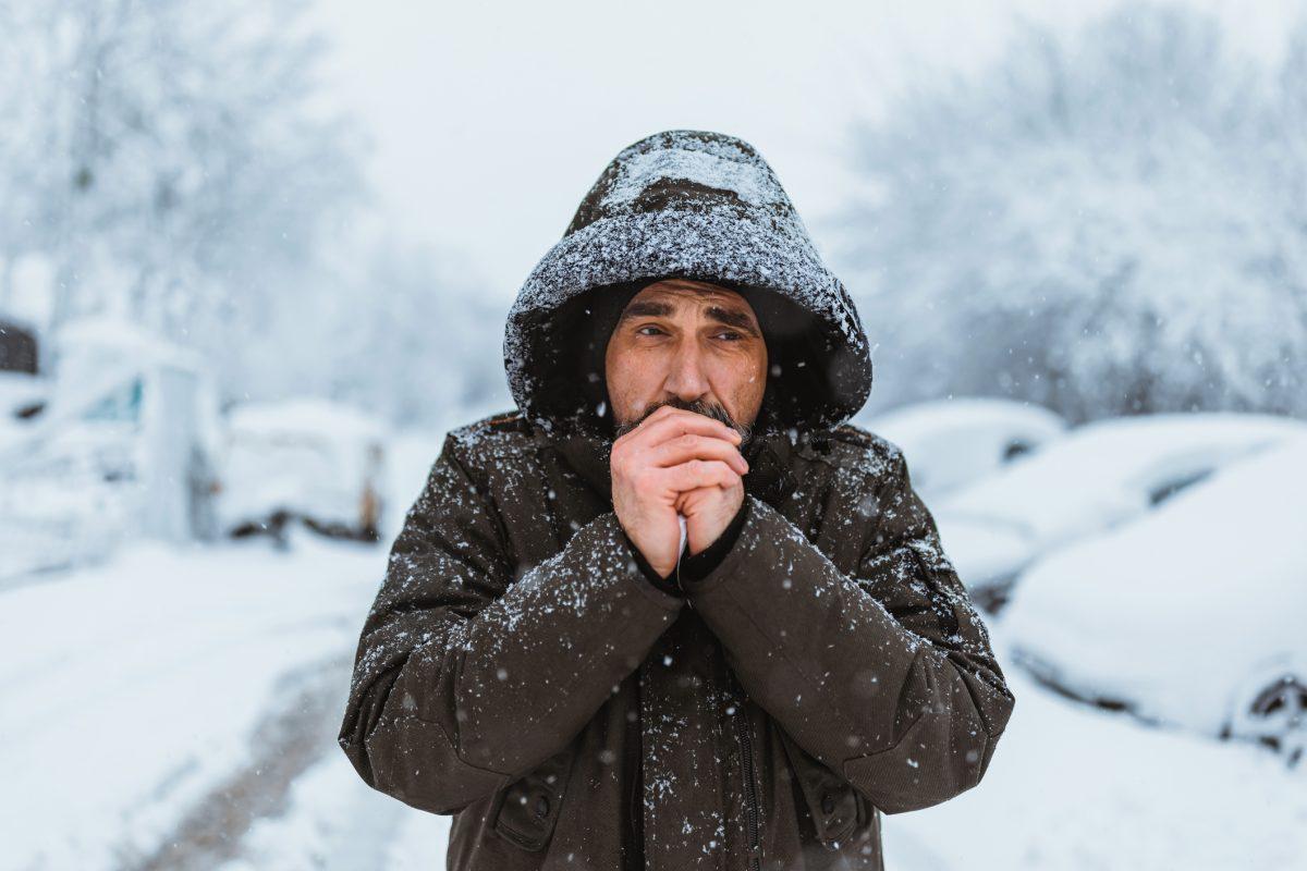 Portrait of the caucasian man in a hat on the street in winter.