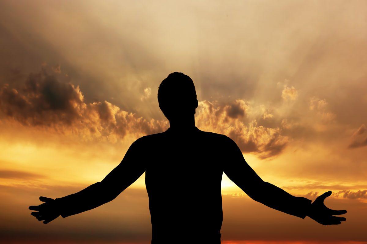 Man praying, meditating in harmony and peace at sunset. Religion, spirituality, prayer, peace.