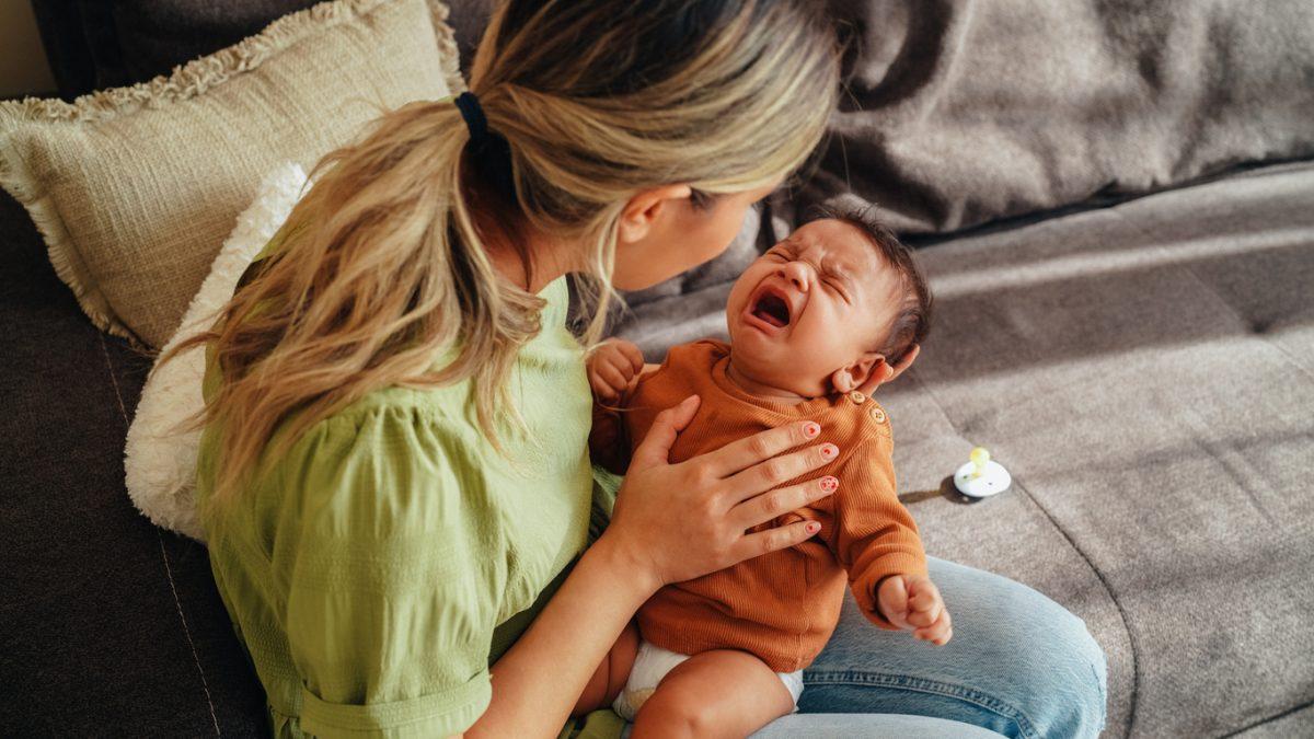 Mother holding in hands a crying baby
